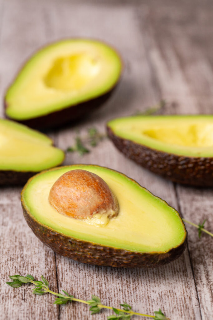 Avocado composition cutted in half on a wooden board.